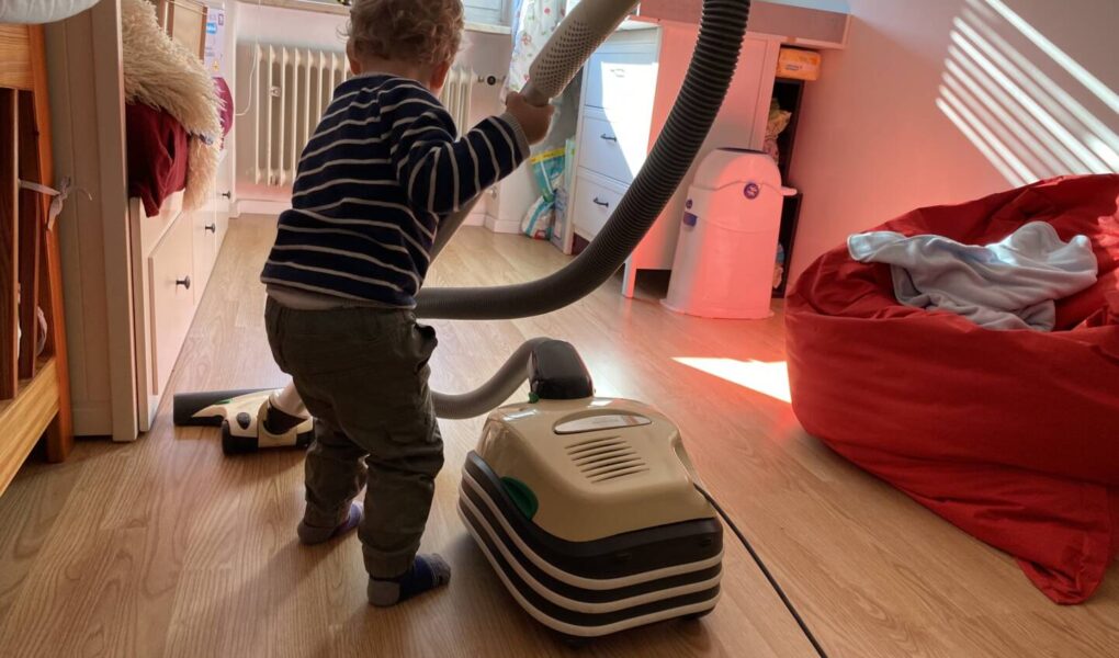 Ein Kind Hilft im Haushalt indem es sein Kinderzimmer gerne selbst saugt.