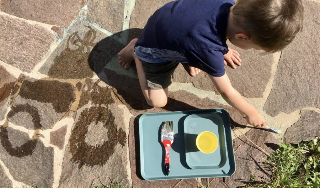 Kind malt mit Wasser - ein Spiel, das nicht viel Material benötigt