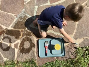 Kind malt mit Wasser - ein Spiel, das nicht viel Material benötigt