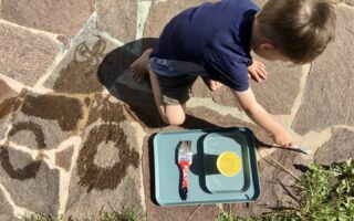 Kind malt mit Wasser - ein Spiel, das nicht viel Material benötigt