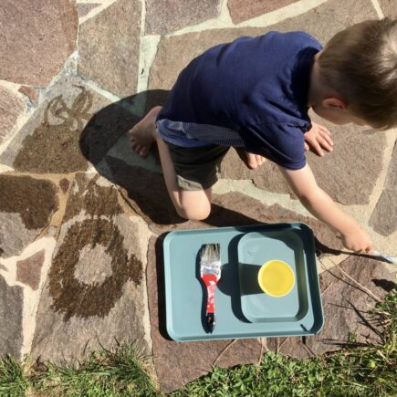 Kind malt mit Wasser - ein Spiel, das nicht viel Material benötigt