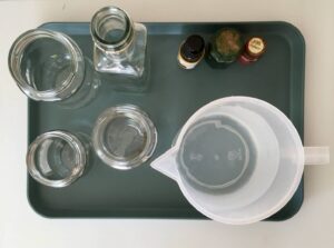 Verschiedene Behälter, Lebensmittelfarbe und Kanne